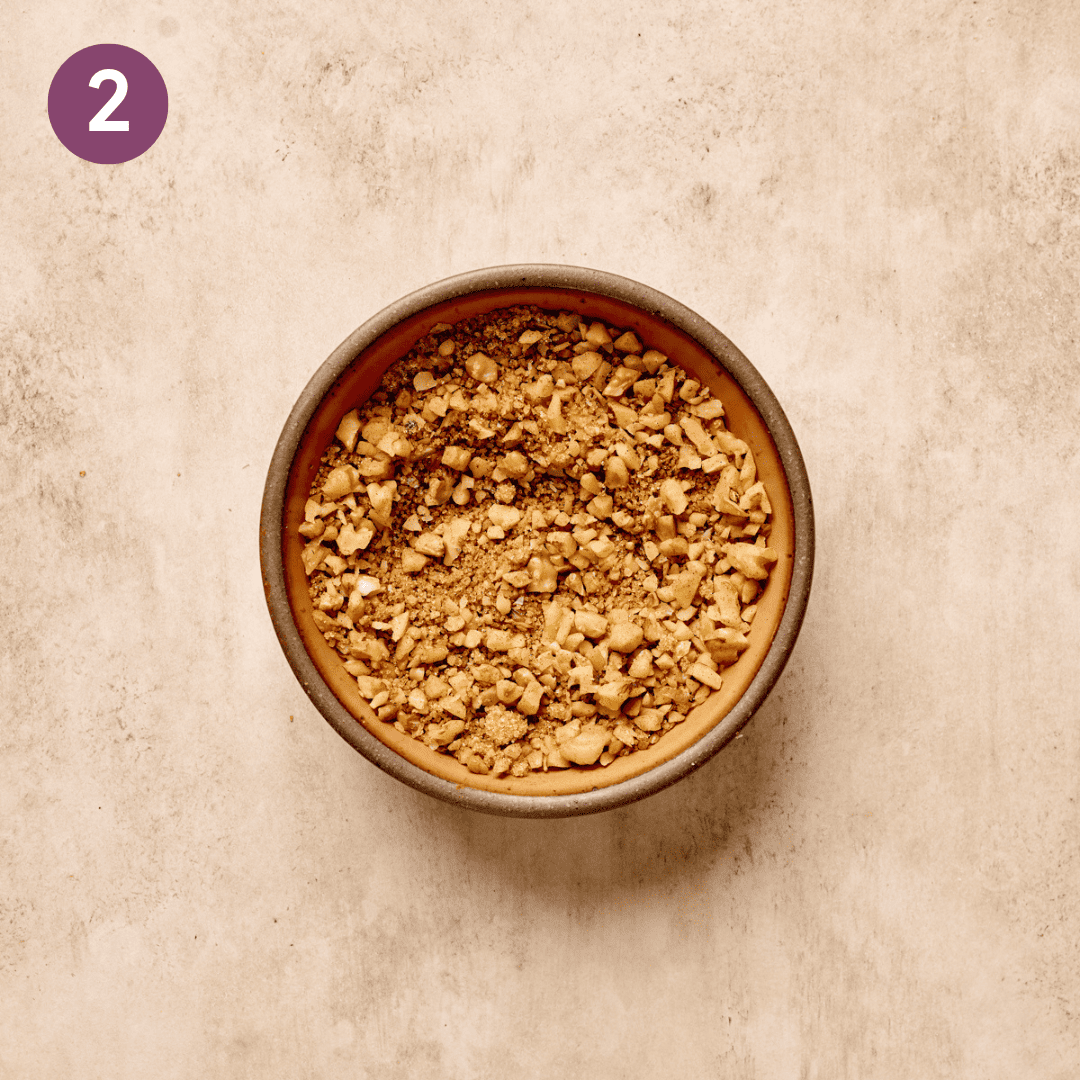 Mixed walnut crumble ingredients in a small bowl on a table.