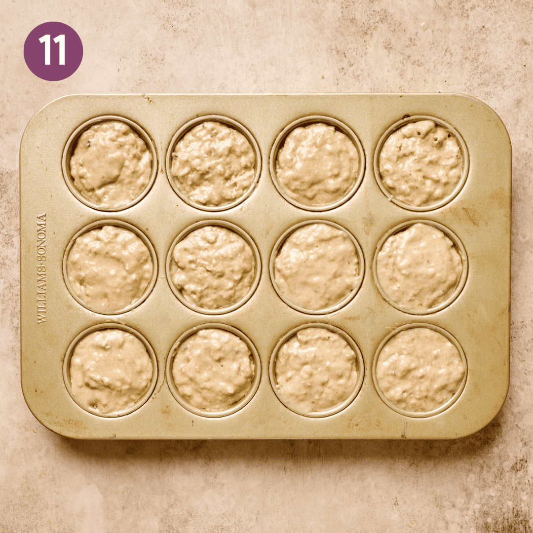 Muffin batter in a greased muffin tin.