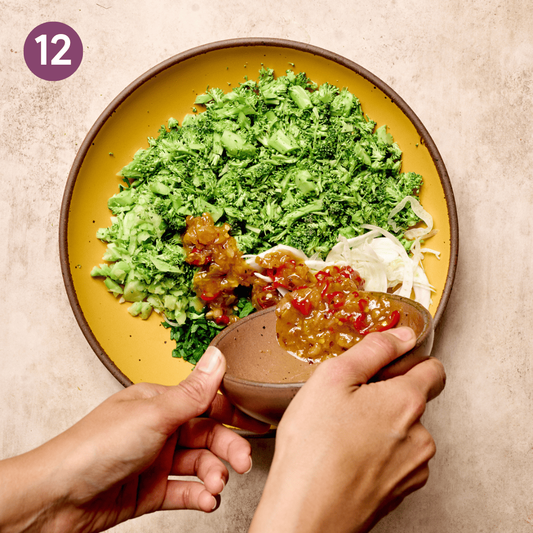 Person pouring some of the dressing over the top of the salad.
