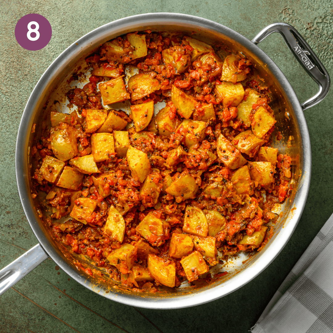 potatoes added to the masala in the pan.