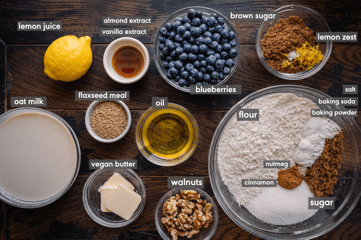 labeled ingredients for vegan blueberry muffins on wooden board.