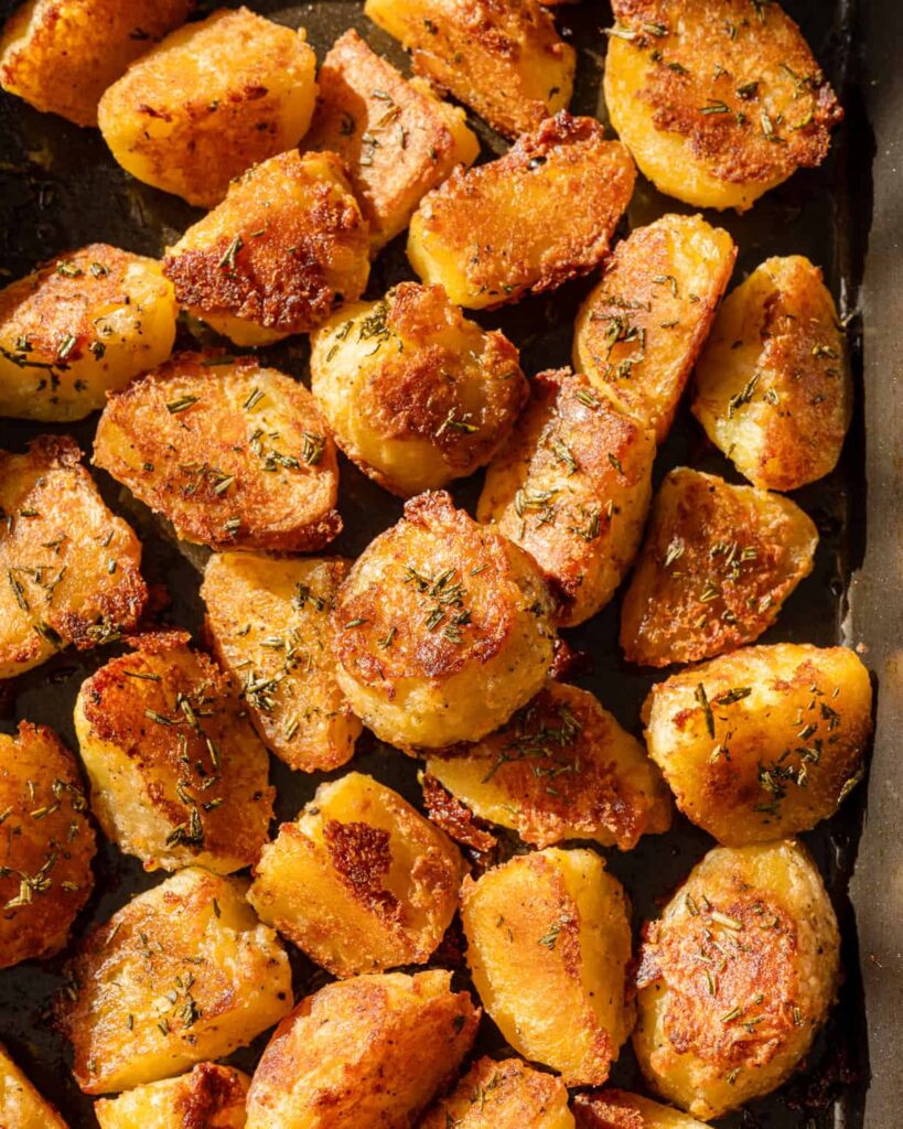 Close up photo of crispy roasted potatoes on a pan.