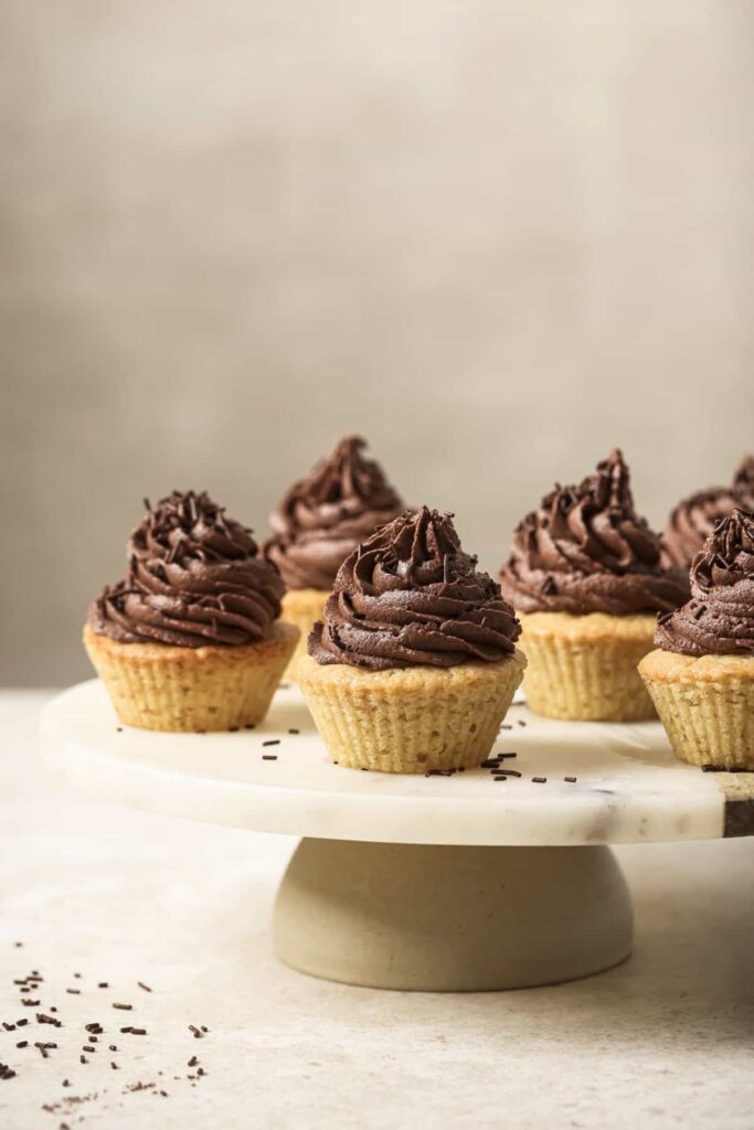 Cupcake with a bite taken out of it on a plate.